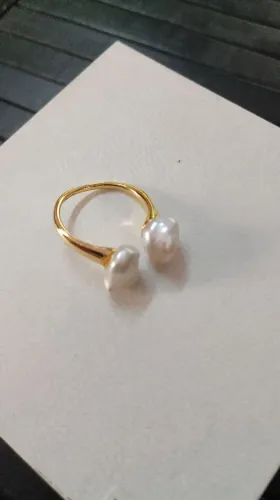 anel aberto ajustável banhado a ouro com duas pérolas barrocas nas extremidades.