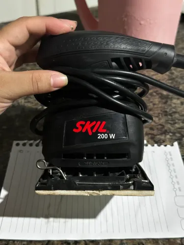 Lixadeira Orbital Skil 7232 preta com 200W de potência.
