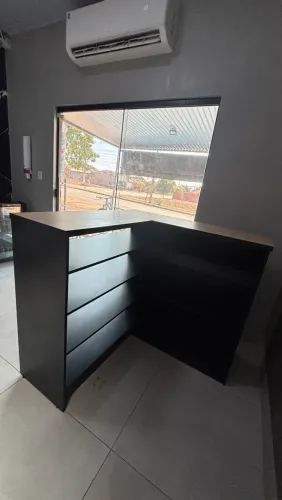 Balcão de recepção em L preto com tampo madeira