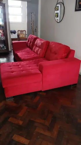 Sofá vermelho usado com almofadas de encosto em capitonê (ou com botões)