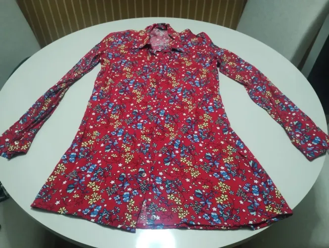 Camisa manga comprida, alongada e fechamento com botões.
