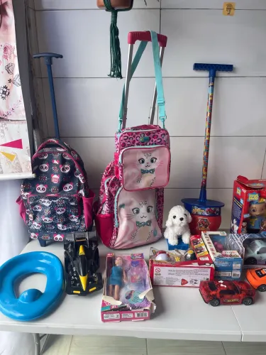 Brinquedos novos e bolsa escolar usadas