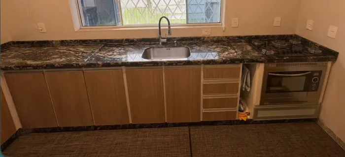 Cozinha planejada em L com tampo de granito e cuba inox