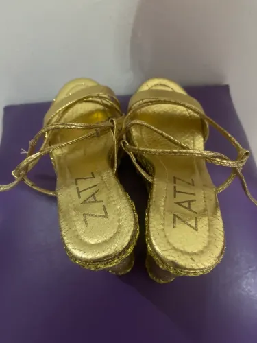 SAPATO DOURADO TRANÇADO NA PERNA 