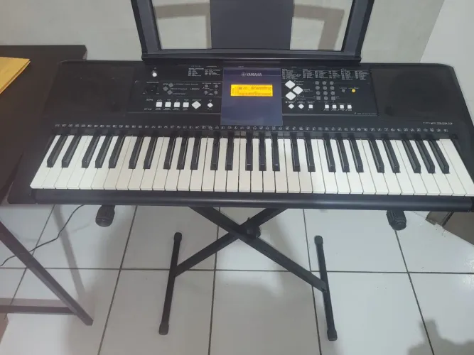 teclado Yamaha PSR-E333 preto com 61 teclas e visor LCD iluminado em laranja.
