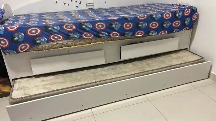 Cama solteiro branca com cama auxiliar e duas gavetas acompanha dois colchões.