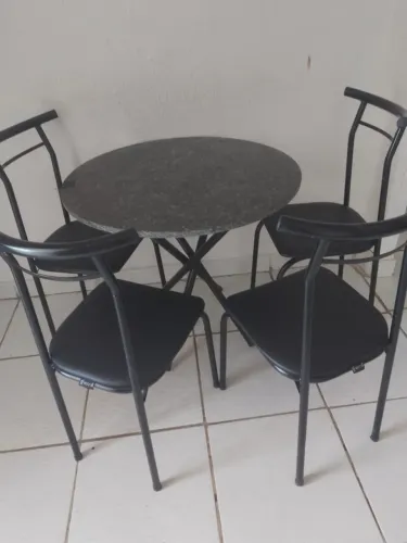Mesa redonda, de quatro cadeiras.
