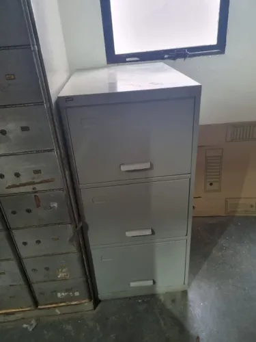 Gaveteiro de aço cinza com três gavetas.