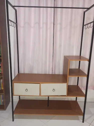 Guarda roupa aberto com gaveta e prateleira.