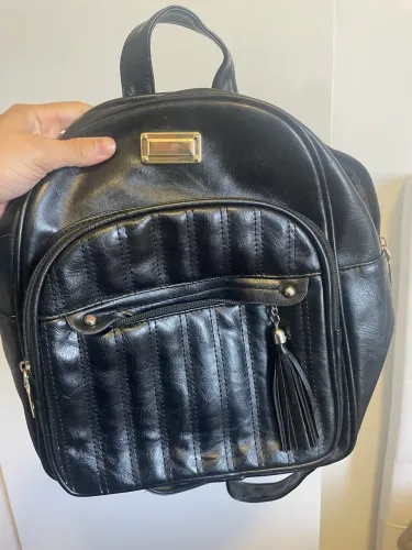 Mochila preta em material sintético (couro ecológico) com tassel