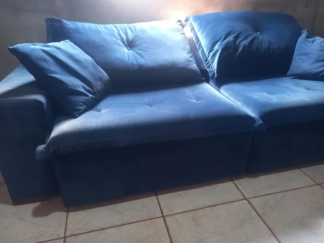 Sofá retrátil e reclinável de cor azul com detalhes de couro