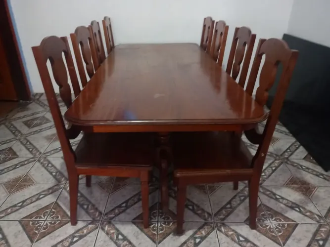 Mesa com 8 cadeiras de madeira maciça.