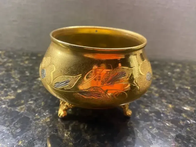 Bomboniere com cena floral em metal dourado e estilo árabe.