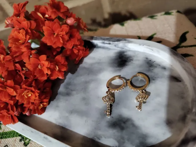 Brinco de argola fechada chave cravejado de zircônia folheado em ouro 18k 