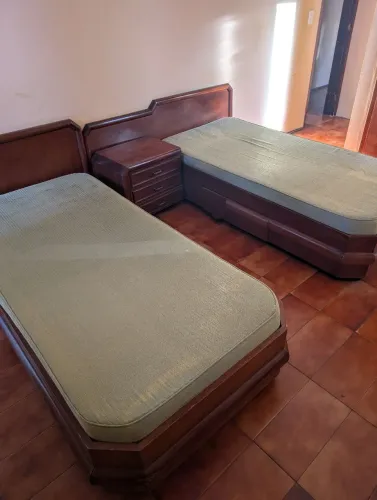 Conjunto de duas camas de solteiro em madeira pequenas, com mesinha de cabeceira,