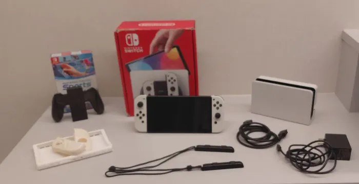 Nitendo Switch OLED com capinha, película, caixa e jogo.