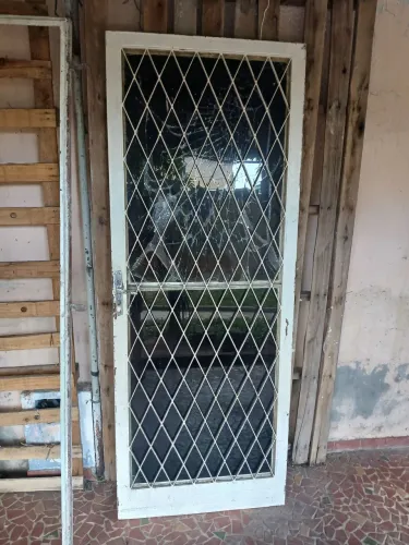 Porta de ferro maciço, completa, com fechadura e portal. Obs vidro de cima quebrado.