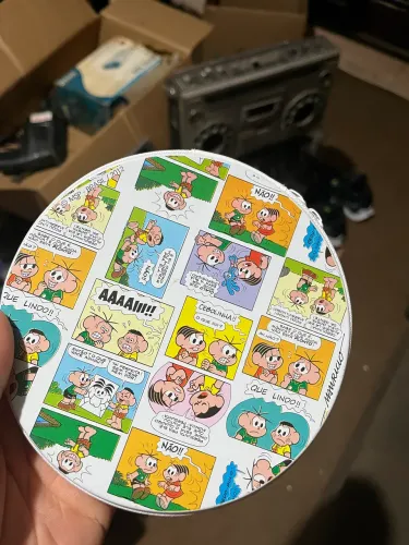 porta-CD de metal com estampa de quadrinhos da Turma da Mônica.