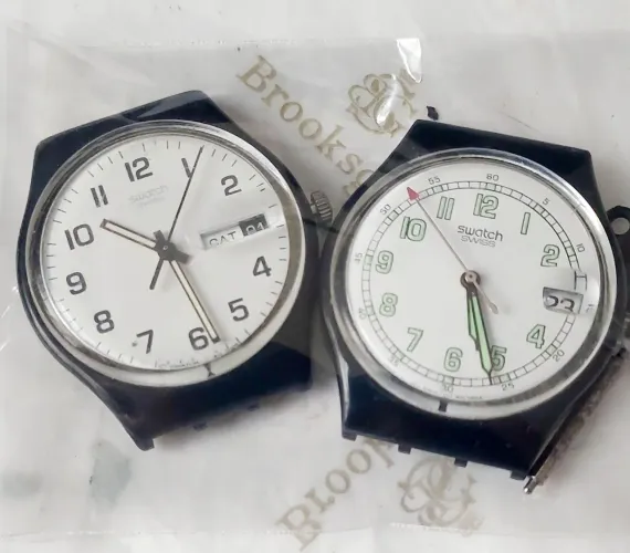 Duas carcaças de relógio swatch.