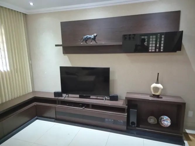 Painel com armário e rack com gavetões para televisão grande, com móvel de canto.
