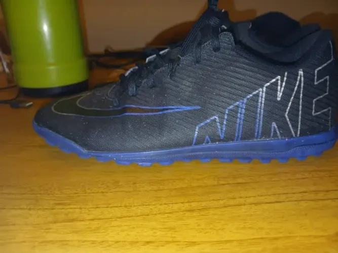 Chuteira Nike Mercurial Vapor 15 Club TF na cor preta e azul.
