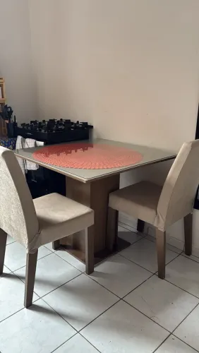 Mesa quadrada com 4 cadeiras com poucas marcas de uso na mesa