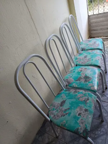 São quatro cadeiras para mesa ela é verde com flores e ramo de costela de Adão
