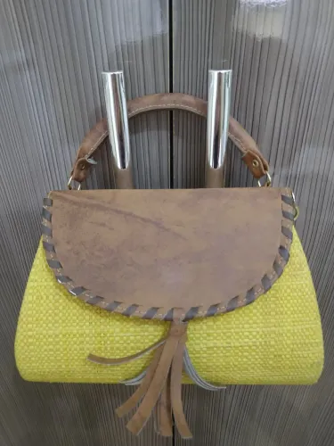 Bolsa de mão em palha amarela com detalhe em couro