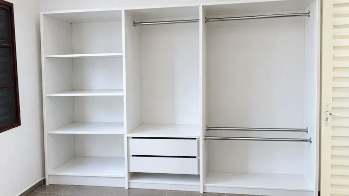 Closet planejado branco com prateleiras e gavetas