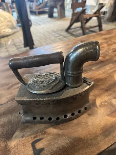 Antiga chapa de ferro fundido para passar roupas de carvão com chaminé