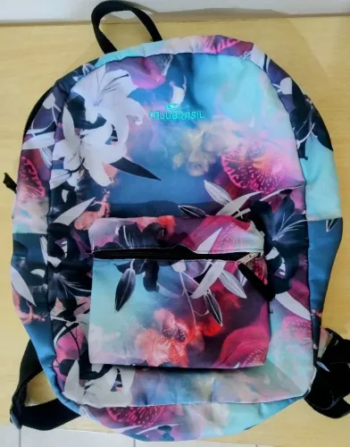 Mochila, em estampa floral e cores vivas.
