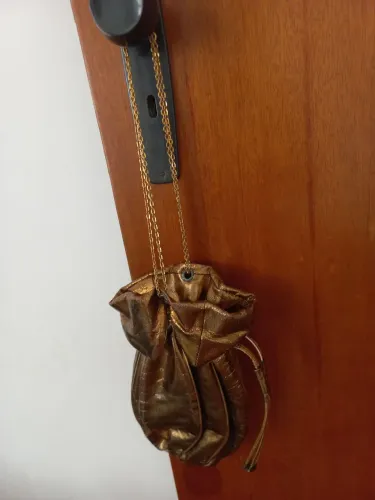 Bolsa de mão dourada com corrente