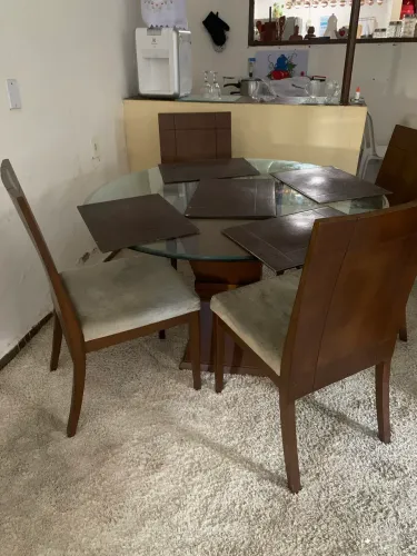 Sala de jantar com tapete, 6 cadeiras e mesa redonda de madeira com tampo de vidro