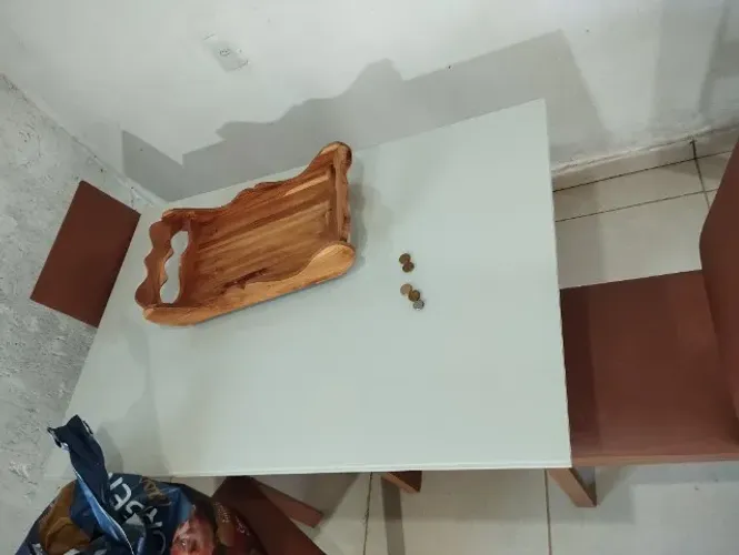 Mesa de baixo do vidro tem uma madeira branca.