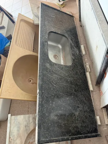 Bancada de granito preto com cuba em inox, retirada durante a reforma de um apartamento.