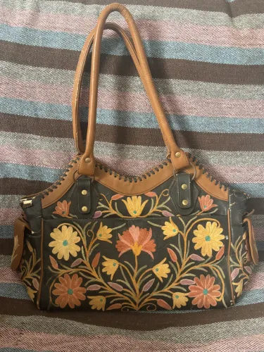 Bolsa de couro com detelhes de flores usada 