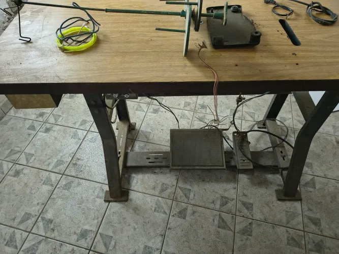 Mesa máquina de costura com motor funcionando.