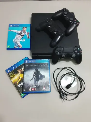 Play 4 Slim com 3 controles e 3 jogos.