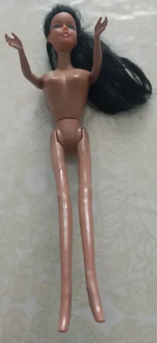 Uma boneca barbi a bela com cabelo preto usada
