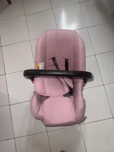 um Bebê Conforto Cosco Kids Wizz na cor rosa mescla