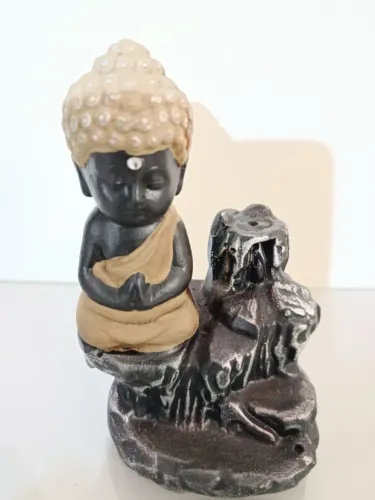 Incensário de resina com estátua de Buda sentado perto a uma rocha. Linda peça