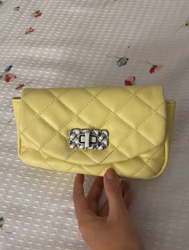 Bolsa mini matelassê amarela com corrente entrelaçada