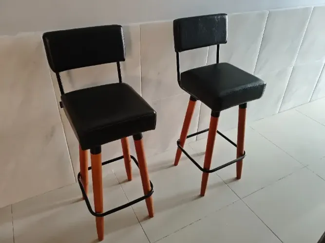 Par de banquetas altas pretas com pés de madeira