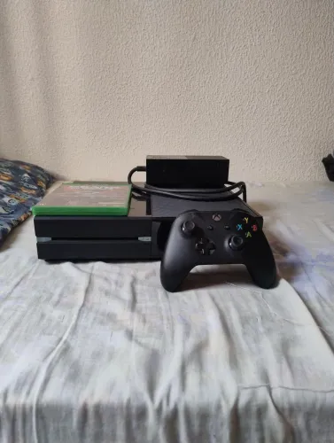 Xbox one com um controle e um jogo