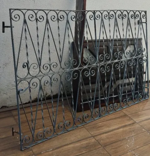 Mesa, janela de madeira e grades de ferro.