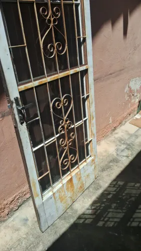 Porta de ferro com grade e vidros, reforçada sem batente.