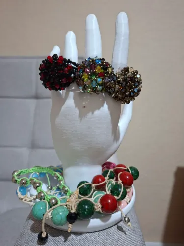 Anéis em cristais Swarovski e pulseiras e macramê e contas coloridas.