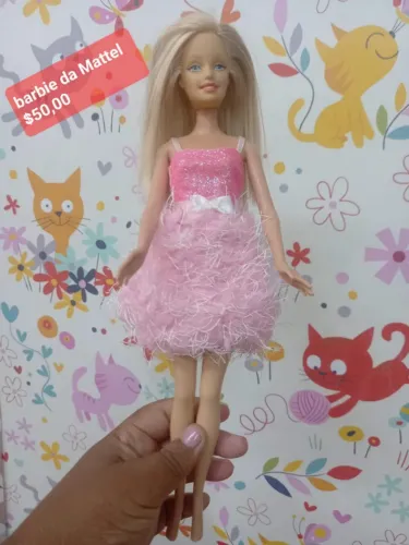 Esta imagem mostra uma boneca Barbie da Mattel com cabelos longos e loiros, vestindo um ve