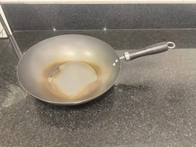Panela wok de aço carbono e cabo de baquelite.