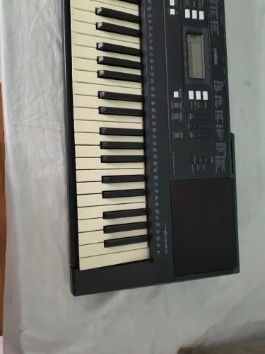 Um teclado Yamaha psr 343,mas a capa fonte e pedal